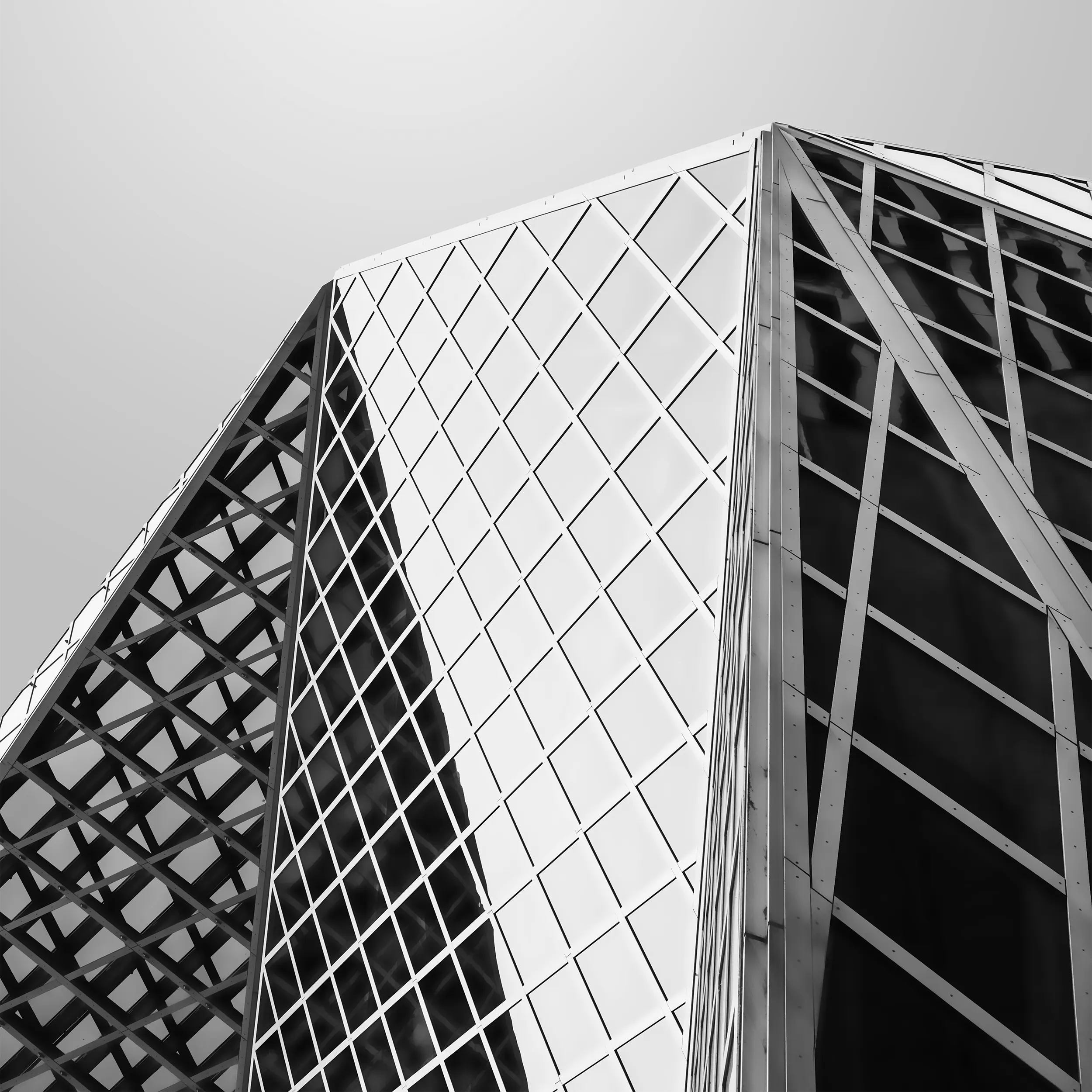 Black and white architectural photograph of Seattle Public Library's geometric glass and steel exterior featuring intersecting diagonal patterns